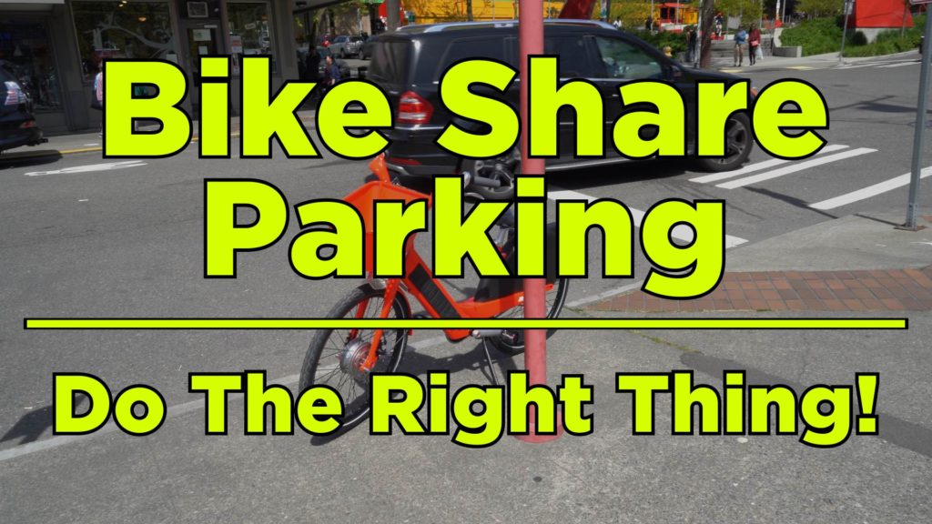 Bike Share Bike parked on sidewalk with text "Bike Share Parking - Do The Right Thing!" in front.