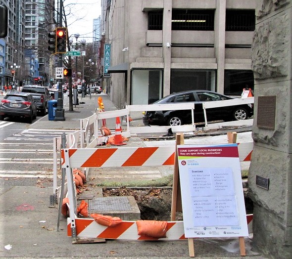 Bus sign next to an open construction area