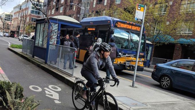 Bicycle rider next to a Seattle city bus